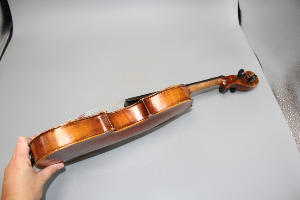 A violin with two piece back and bow, and a childs violin with bow, both with cases